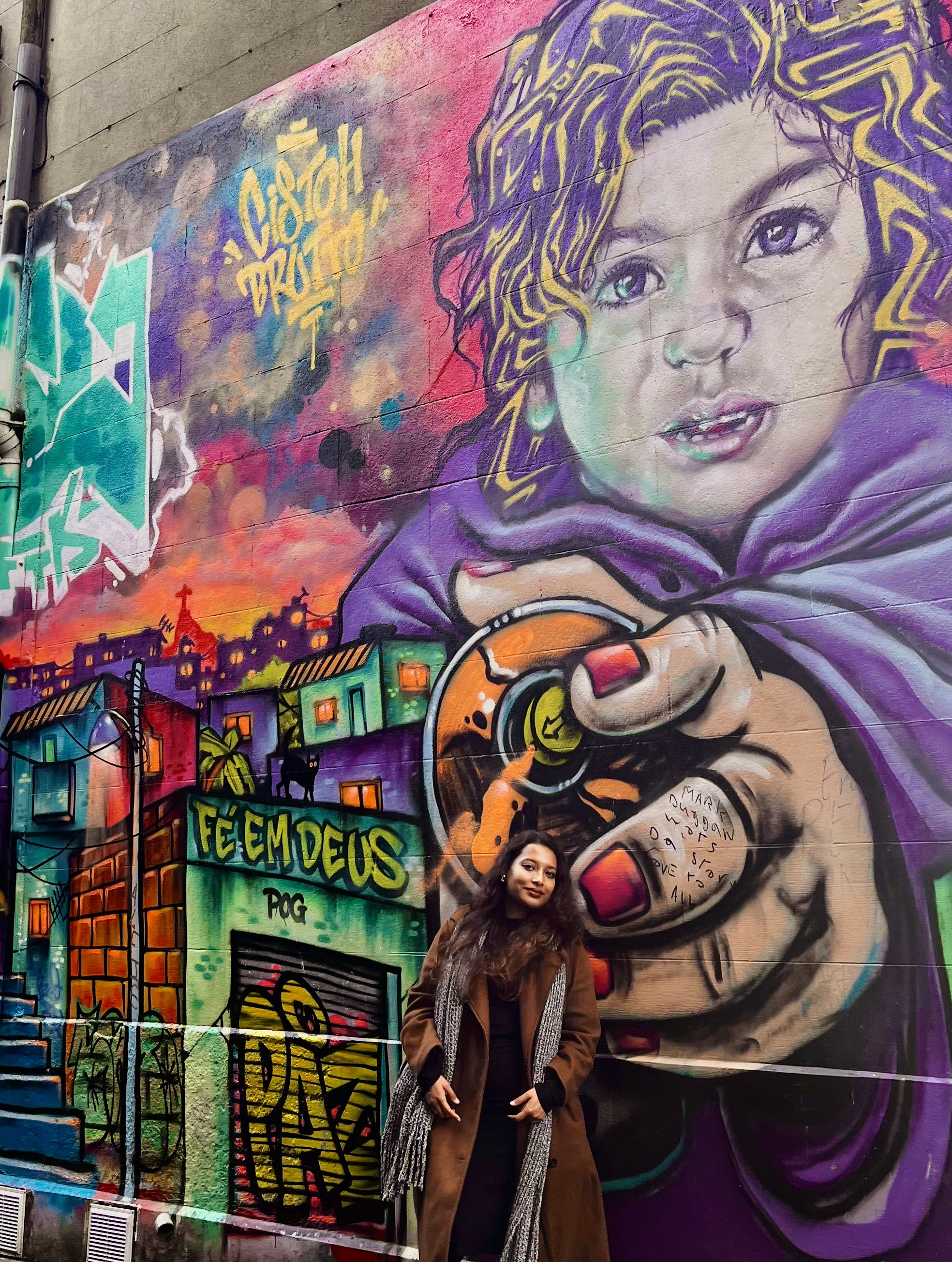 Amrita Bakshi before a street mural
